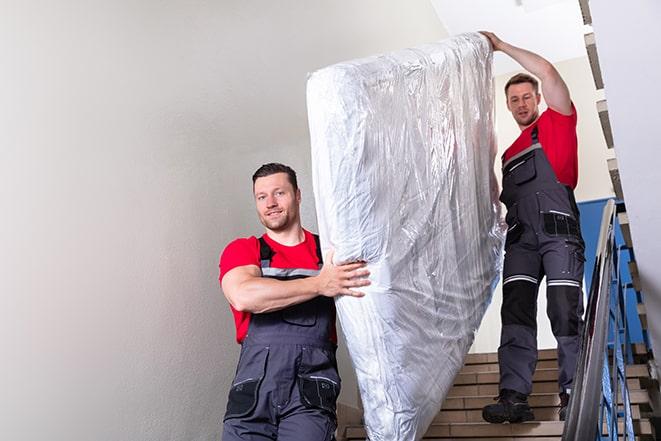 team of workers handling a box spring for disposal in Ben Lomond